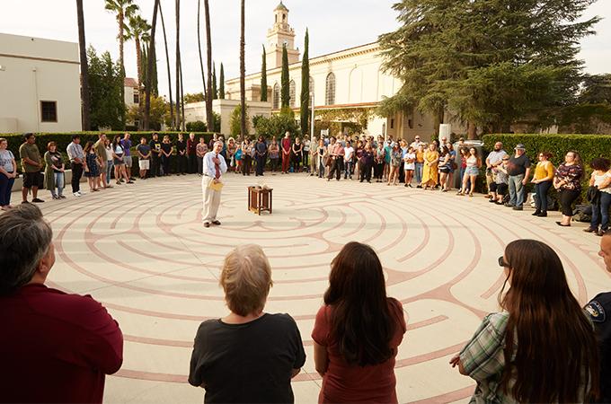 People stand in a circle around the labyrinth at the University of Redlands.